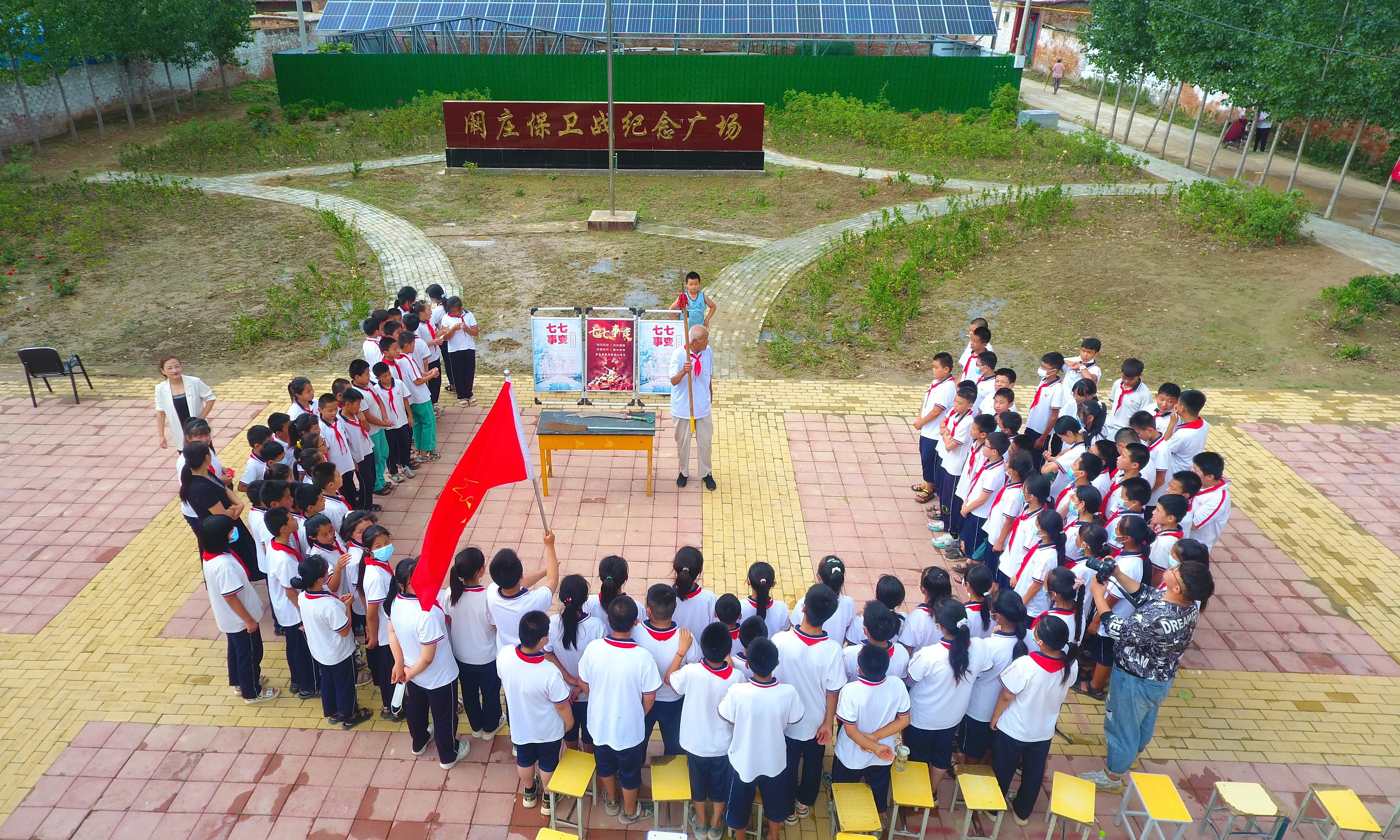 2022年7月6日，山東省聊城市，在茌平區(qū)菜屯鎮(zhèn)闞莊村的闞莊保衛(wèi)戰(zhàn)紀(jì)念廣場(chǎng)，闞莊保衛(wèi)戰(zhàn)親歷者王光木老人，為小學(xué)生們講述抗戰(zhàn)故事，展示大刀、長(zhǎng)矛。