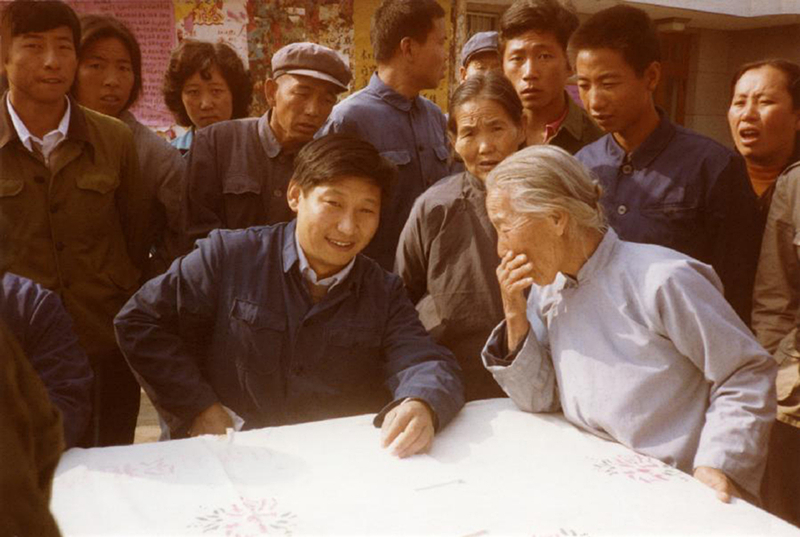 1983年，時(shí)任河北正定縣委書記的習(xí)近平（前排居中），臨時(shí)在大街上擺桌子聽取老百姓意見。